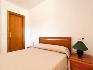 een slaapkamer met een bed en een lamp op een dressoir bij Bella Terraza frontal al Mar in Oropesa del Mar