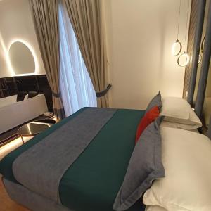 een slaapkamer met een bed met kussens en een raam bij La Lepre felice in Napels