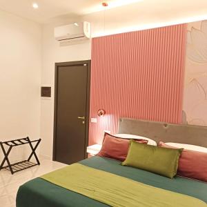 een slaapkamer met een bed en een rode muur bij La Lepre felice in Napels