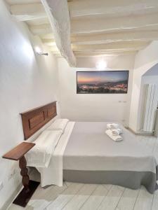 a white bedroom with a bed and a table at ADG Apartment 33 in Florence