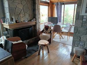 a living room with a fireplace and a table and chairs at Parnassos Ski Chalet in Arachova