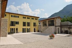 a large yellow building with mountains in the background at Agriturismo Tre Forti in Rivoli Veronese