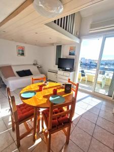 ein Esszimmer mit einem Tisch und Stühlen sowie ein Schlafzimmer in der Unterkunft Appartement coup de coeur les pieds dans l'eau in Le Barcarès