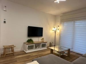 sala de estar con TV de pantalla plana en la pared en Vista Golf, en Valencia