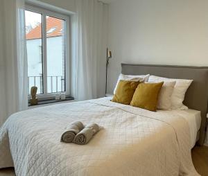 sypialnia z dużym białym łóżkiem z żółtymi poduszkami w obiekcie Stilvolles Zimmer mit Bad im historischen Stadtkern von Xanten w mieście Xanten