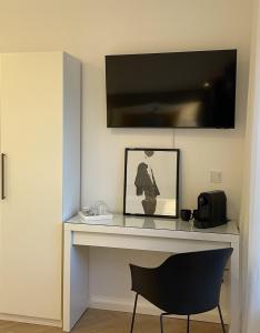 einen Schreibtisch mit Stuhl und einen TV an der Wand in der Unterkunft Stilvolles Zimmer mit Bad im historischen Stadtkern von Xanten in Xanten