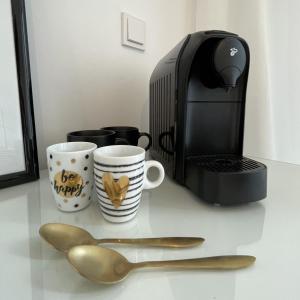 eine Theke mit zwei Löffeln neben einer Kaffeemaschine in der Unterkunft Stilvolles Zimmer mit Bad im historischen Stadtkern von Xanten in Xanten