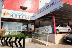 a grand white hotel with a car parked in it at Hotel Grandville II in Palmeira dos Índios