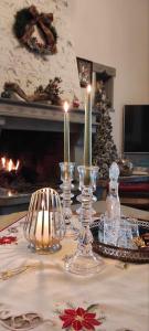 a table with three candles and a christmas tree at Yiayias House Tzoumerka in Plaka