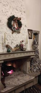 a fireplace with christmas wreaths on a brick wall at Yiayias House Tzoumerka in Plaka