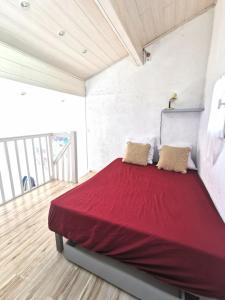 a bedroom with a large bed with red sheets at Appartement coup de coeur les pieds dans l'eau in Le Barcarès