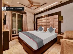 a bedroom with a large bed and a couch at Super Townhouse Acme Near Park Street in Kolkata