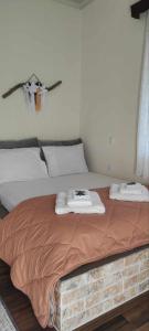 - un lit avec 2 serviettes dans l'établissement Yiayias House Tzoumerka, à Plaka
