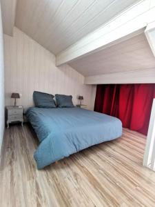 a bedroom with a large bed with a red curtain at Appartement coup de coeur les pieds dans l'eau in Le Barcarès