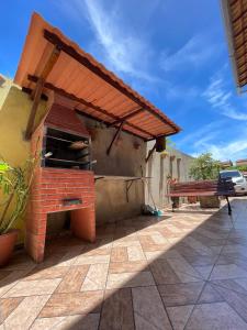 an outdoor grill with a bench on a patio at Vila da Drika in Rio das Ostras