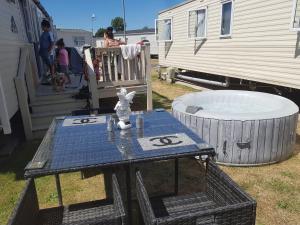 una mesa de picnic y una bañera junto a una caravana en 8 Birth Mobile Luxury home C016 8SG St Osyth near Clacton on Sea en Clacton-on-Sea