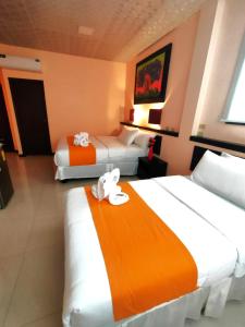 um quarto de hotel com duas camas com toalhas em Hotel Los Algarrobos em Puerto Baquerizo Moreno