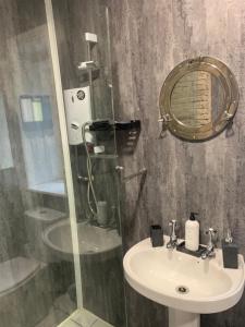a bathroom with a sink and a mirror and a shower at Hays cottage in Halifax