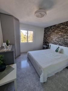 um quarto com uma cama grande e uma parede de tijolos em Casa Oso em Vilanova i la Geltrú