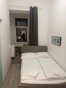 una camera da letto con un letto con lenzuola bianche e una finestra di Speedyrooms Vienna a Vienna
