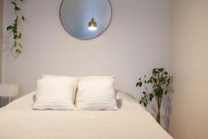 a bed with two pillows and a mirror on the wall at Luxury Nordic Loft with Great Kitchen and Location in Helsinki