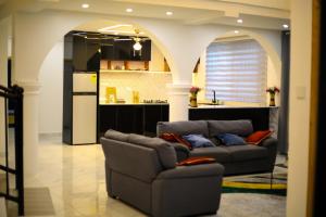 a living room with a couch and a kitchen at MILYREX VILLA 