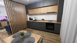 a kitchen with a wooden table and a counter top at Alexia Flat in Sibiu +10 photos