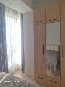un gran armario de madera con espejo en un dormitorio en Apartment, en Tiflis