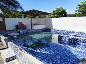 - une piscine avec un mur bleu et blanc dans l'établissement Villas Higuer, à Escuintla
