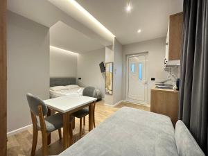 a room with a table and chairs and a bedroom at Maison Apartments in Vlorë