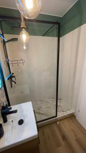 a bathroom with a glass shower and a sink at Alexia Flat in Sibiu