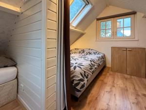Habitación pequeña con cama y ventana en Cosy Groede, en Schoondijke