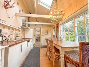 cocina con mesa, sillas y lámpara de araña en Cosy Groede, en Schoondijke