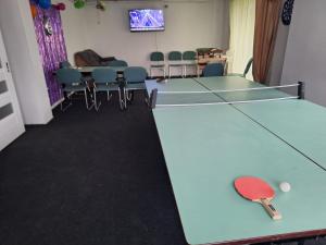 una stanza con tavolo da ping pong e sedie di Skotnicki Zakątek u Magdy i Tomka a Samborzec