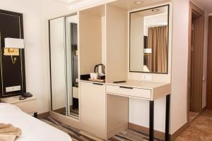 a hotel room with a desk and a mirror at Shelter Inn Hotel & Spa in Ankara