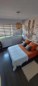 a bedroom with a large bed with orange pillows at F3 avec jardin et piscine in Montpellier