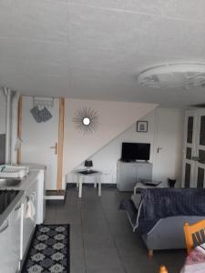 uma sala de estar com um sofá e uma mesa em studio 2 personnes em Luxeuil-les-Bains