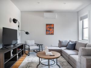 sala de estar con sofá y TV en Modern Three Bedroom Brooklyn Condo-Hotel, en Brooklyn