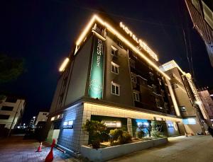 um edifício com um sinal verde à noite em Series hotel em Gyeongju