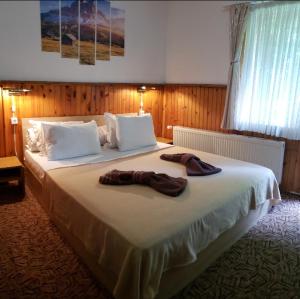 a bedroom with a large bed with two shoes on it at Guest Rooms- KLEPALSKI House in Borovets