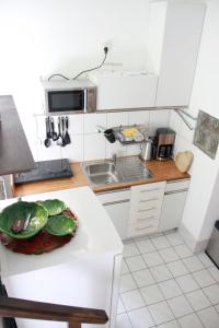 a kitchen with a sink and a bowl of vegetables on a counter at Mosel View in Zell an der Mosel