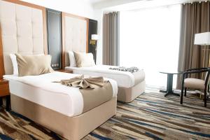 una habitación de hotel con 2 camas y una silla en Shelter Inn Hotel & Spa en Ankara