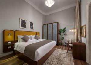 um quarto com uma cama grande, uma secretária e uma cadeira em Lemon Spaces VINTAGE- Downtown em Cairo