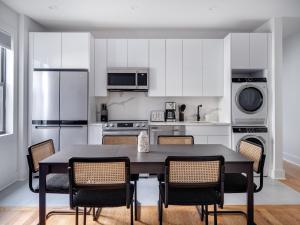 uma cozinha com armários brancos e uma mesa e cadeiras em Modern Three Bedroom Brooklyn Condo-Hotel em Brooklyn