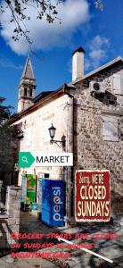 an old building with signs on the side of it at Apartment Mediterraneo Blue Sky in Perast
