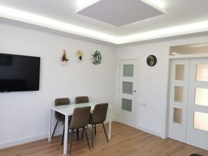 a white dining room with a table and chairs at Ático in Terrassa