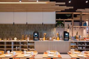 a restaurant with wooden tables and chairs and a counter at Paxton Paris MLV in Ferrières-en-Brie