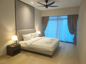 a bedroom with a bed with a ceiling fan and a window at EATON RESIDENCE AT KLCC in Kuala Lumpur