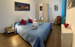 Schlafzimmer mit einem Bett mit blauer Bettwäsche und roten Kissen in der Unterkunft TINTORETTO 1 CON TERRAZZA SOPRA IL TETTO, 3 bagni, 3 grandi camere da letto, SUPER NUOVO in Venedig
