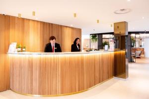 two people sitting at a bar in a lobby at Paxton Paris MLV in Ferrières-en-Brie